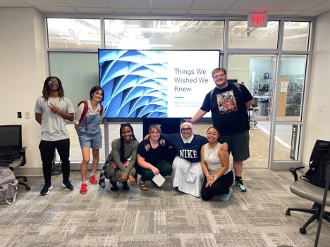 Students in front of a screen that reads "Things we wished we knew" 