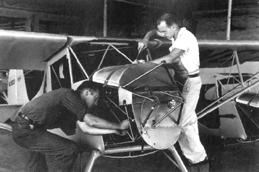 Ray Bisplinghoff and another person work on an airplane.
