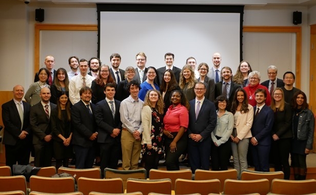 a group of 20 faculty and college students pose 