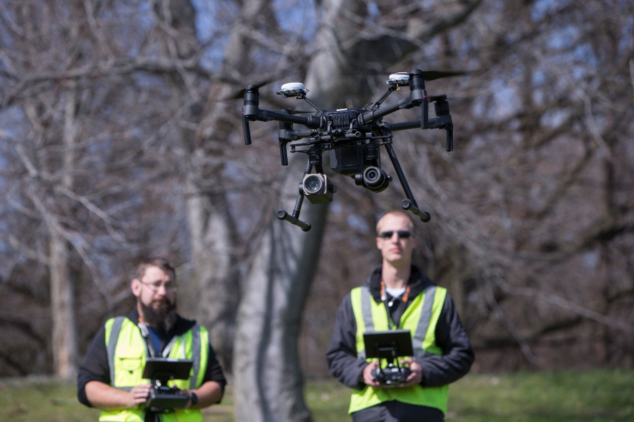Bryan Brown (beard), research associate in UC's College of Engineering and Applied Science (CEAS), and UC engineering student Austin Wessels demonstrate a drone used as part of CEAS's multi-year contract with the Ohio Department of Transportation to study traffic.