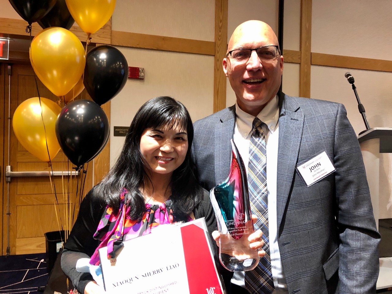 Xiaoqun (Sherry) Liao, standing with Dean John Weidner, was awarded the Mary McCormick Distinguished Staff Award 2020