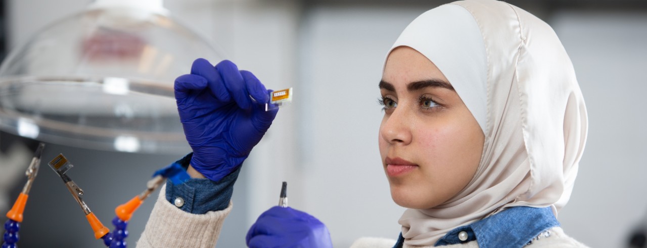 Student examining an item in a lab