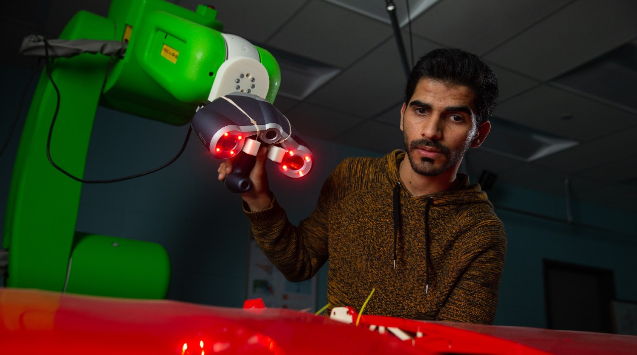 Students pose in Dr. Ou Ma's robotics lab in Rhodes Hall.